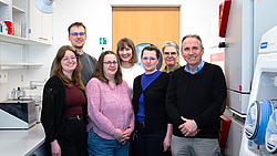 7 Personen stehen für ein Bild zusammen